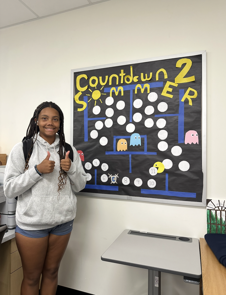 Marie Lyles standing in front of the counseling countdown to summer board.
